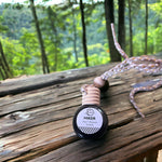Hiker Car Diffuser sitting on table with forest in background