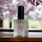 Kyoto Eau de Parfum sitting on wooden table with cherry blossoms in background