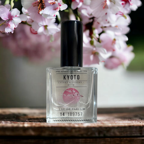 Kyoto Eau de Parfum sitting on wooden table with cherry blossoms in background