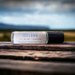 Iceland Perfume Oil laying on wooden table with Iceland in background