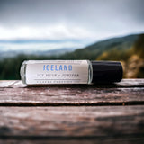 Iceland Perfume Oil laying on wooden table with Iceland in background 