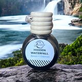 Hidden Waterfall Car Diffuser sitting on rock with waterfall in background