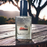 Joshua Tree Eau de Parfum sitting on table with Joshua Trees at sunset in background