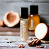 Honey Trap Perfume Oil standing on wooden table with honey in background 