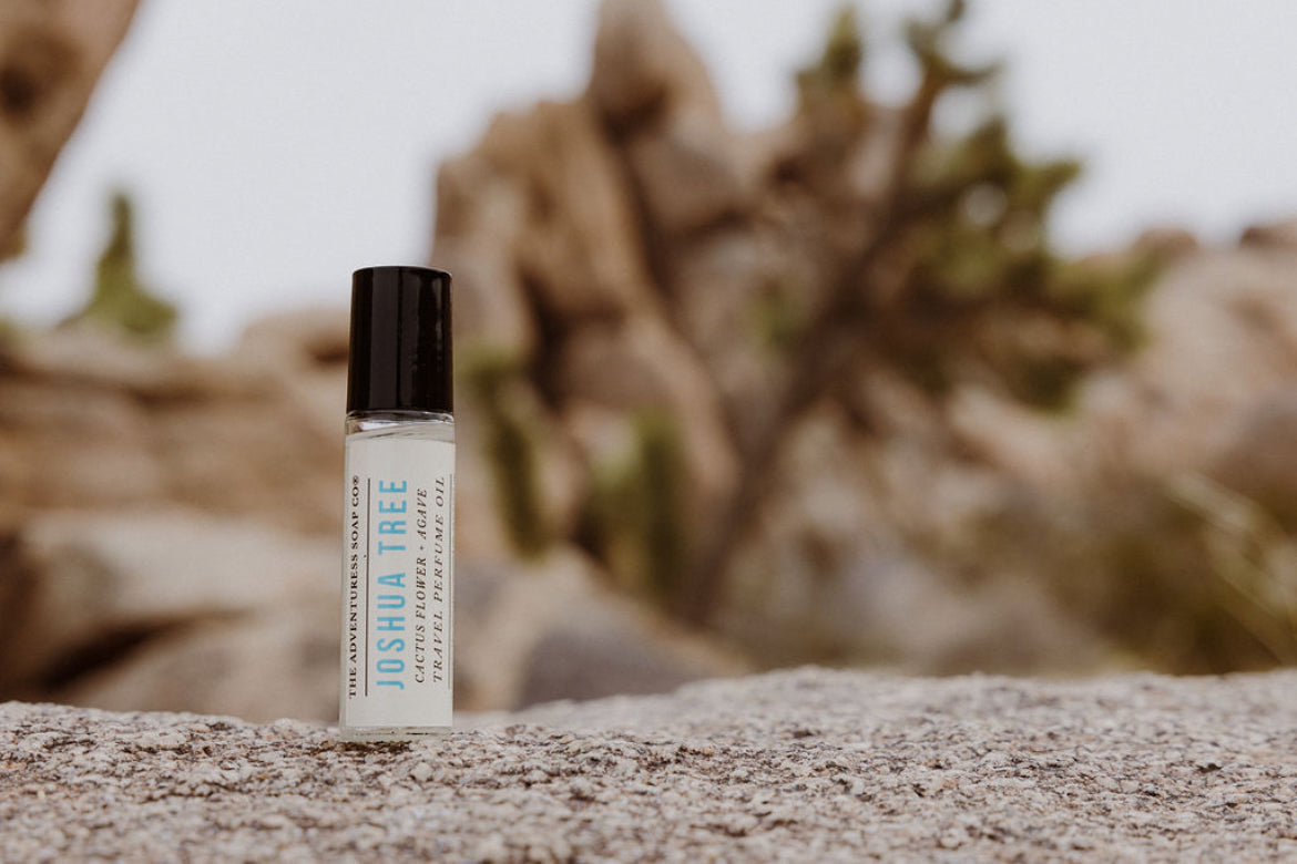 Small bottle labeled 'Joshua Tree' on a textured surface with blurred natural background