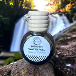 Hidden Waterfall Car Diffuser sitting on rock with waterfall 