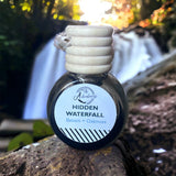 Hidden Waterfall Car Diffuser sitting on rock with waterfall 
