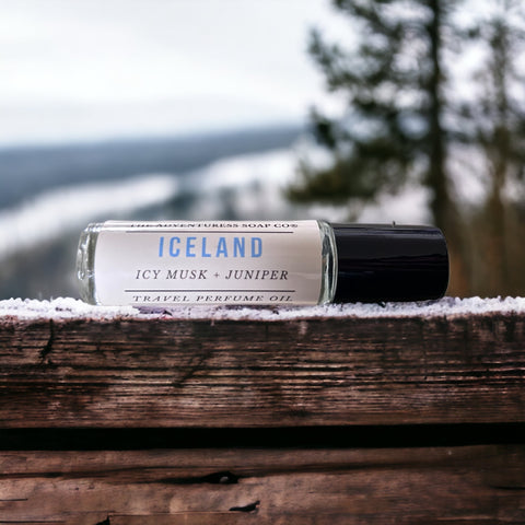 Iceland Perfume Oil laying on wooden table with snowy backdrop 