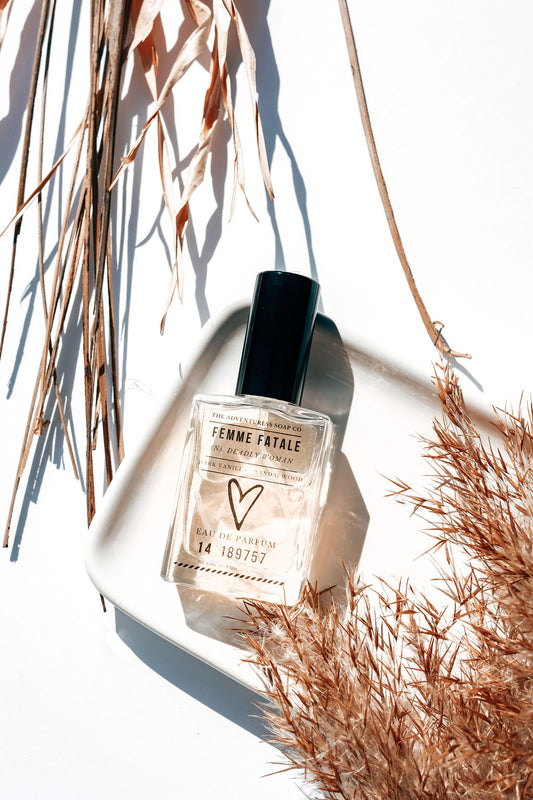 femme fatale perfume laid out on white background with shadows