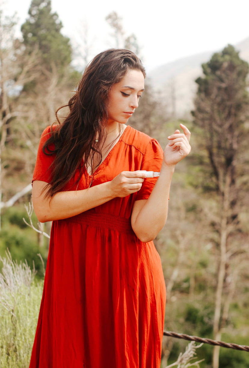 rocky mountains travel perfume oil being applied by woman in mountains