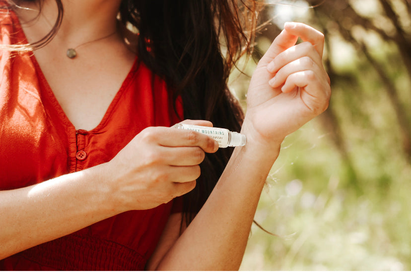 rocky mountains travel perfume oil being applied by woman