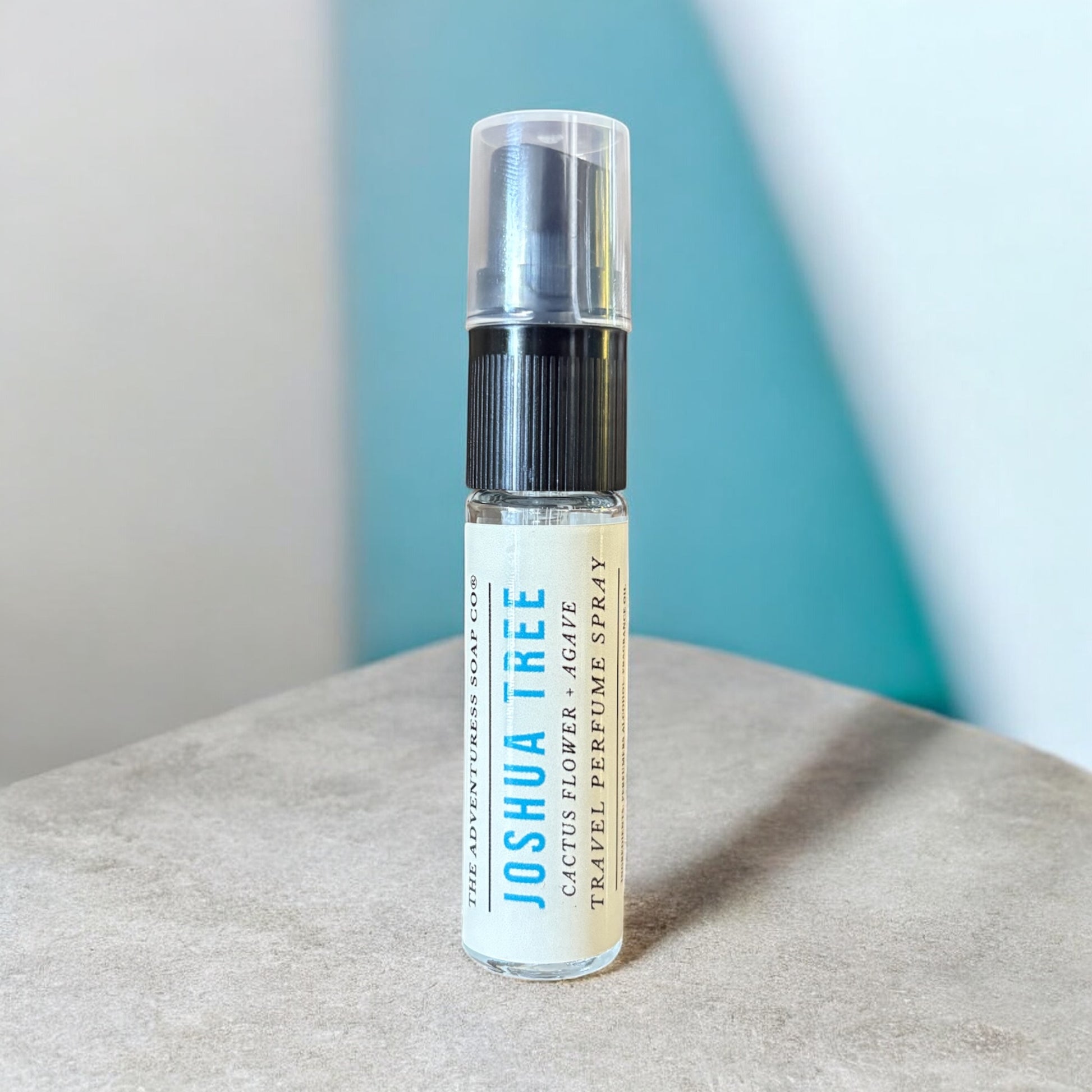 Small spray bottle labeled 'Joshua Tree' on a textured surface with a light blue background