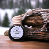 Evergreen Frost Car Diffuser on wooden table with snowy forest in background