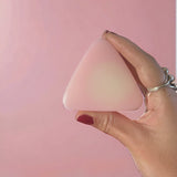 Small pink mountain shaped soap being held in front of pink background