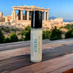 Athens Perfume Oil on wooden table with Acropolis in background.