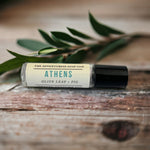Athens Perfume Oil with olive leaf in background.