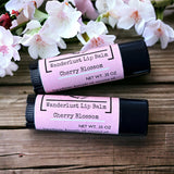 Cherry Blossom Lip Balm on wooden table with flowers in background