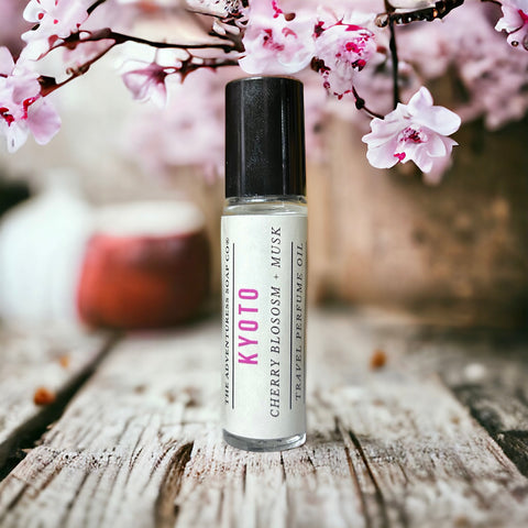 Kyoto Perfume Oil on wooden table with cherry blossoms in background