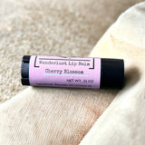 Cherry Blossom lip balm on beige textile background