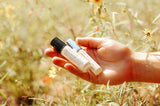 rocky mountains travel perfume oil being held by woman in mountain meadow