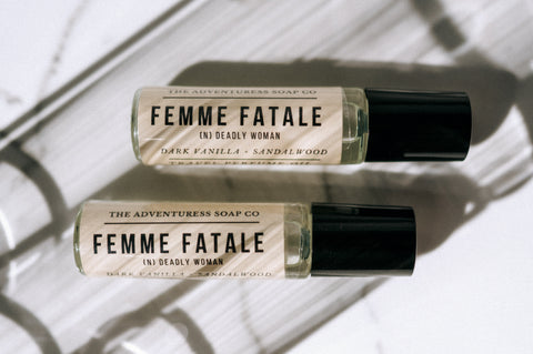 femme fatale perfume oil laid on background with shadows