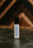 adventuress perfume oil with wooden mountains in background